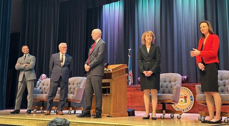 The five court justices who visited the Owens campus standing in a line on stage